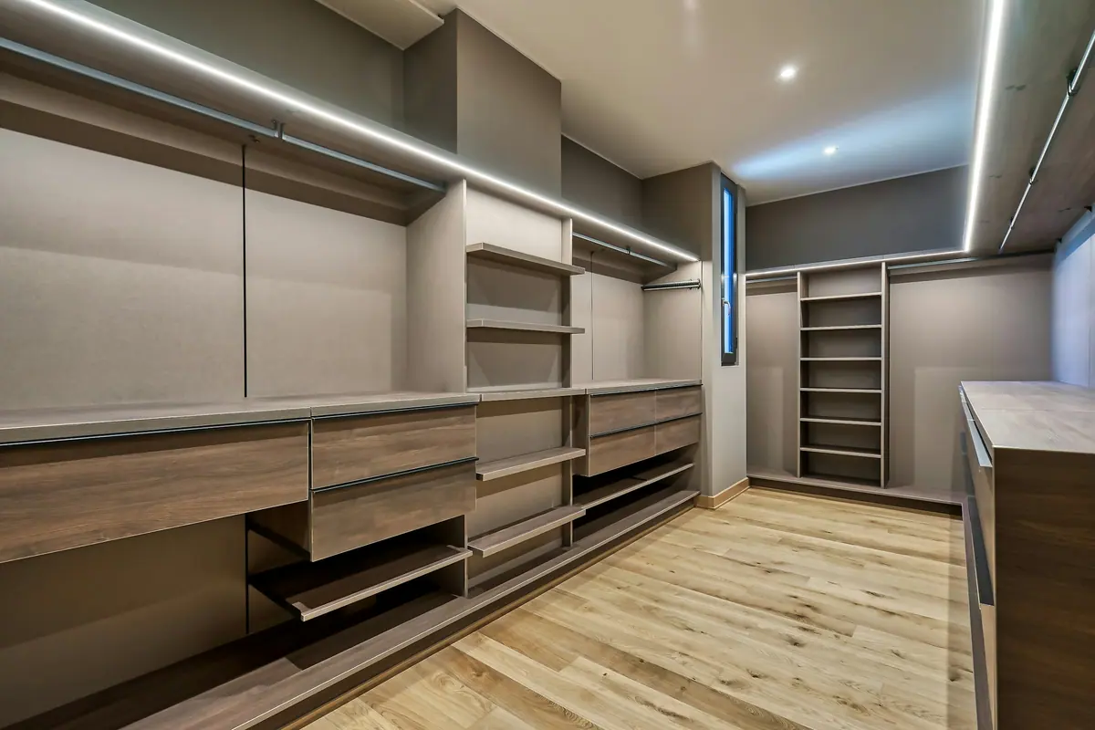 Closet em corredor com gavetas embutidas e iluminação linear